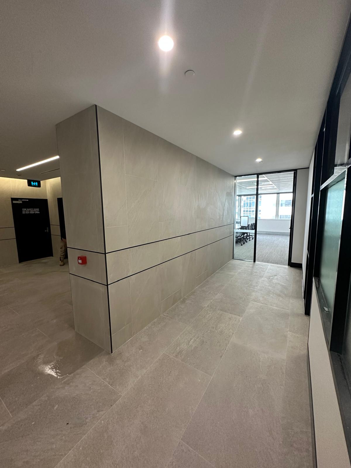 Commercial corridor with large-format grey floor and wall tiles